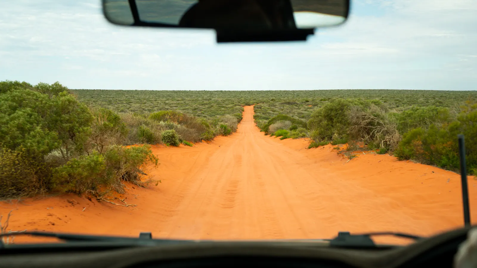 A long red dirt road winding through the outback.